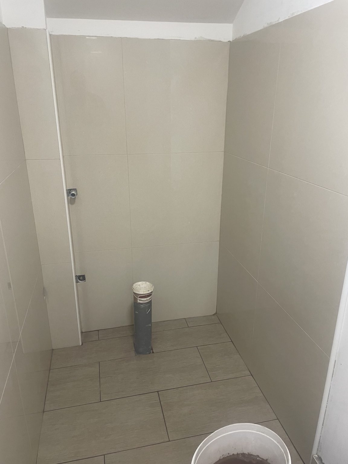 Postavljanje zidne i podne keramike u sanitarnom prostoru tijekom adaptacije kuće.
