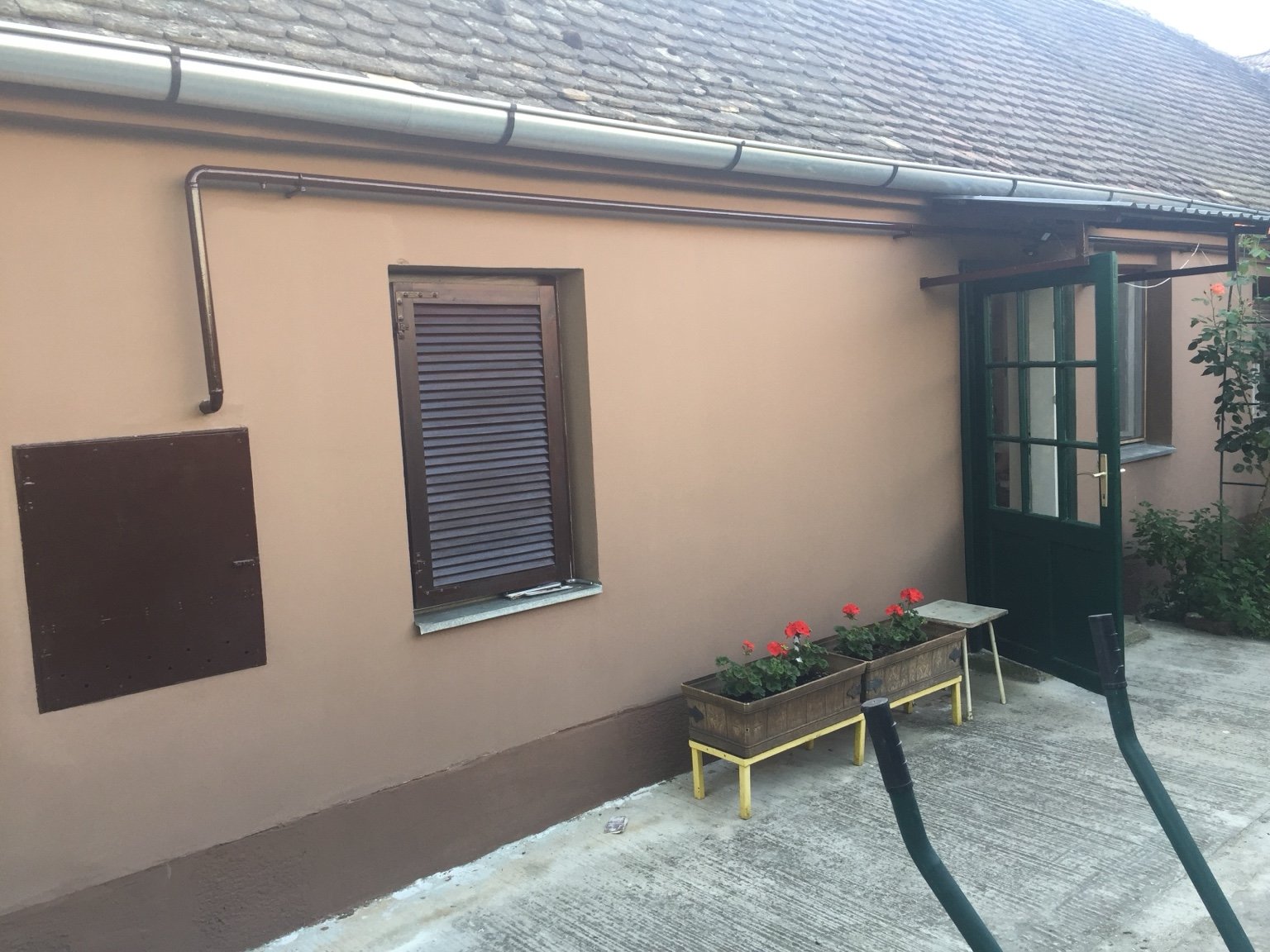 Detalj završno obojane fasade, cokla, stolarije i limenih klupčica na staroj kući u Osijeku.