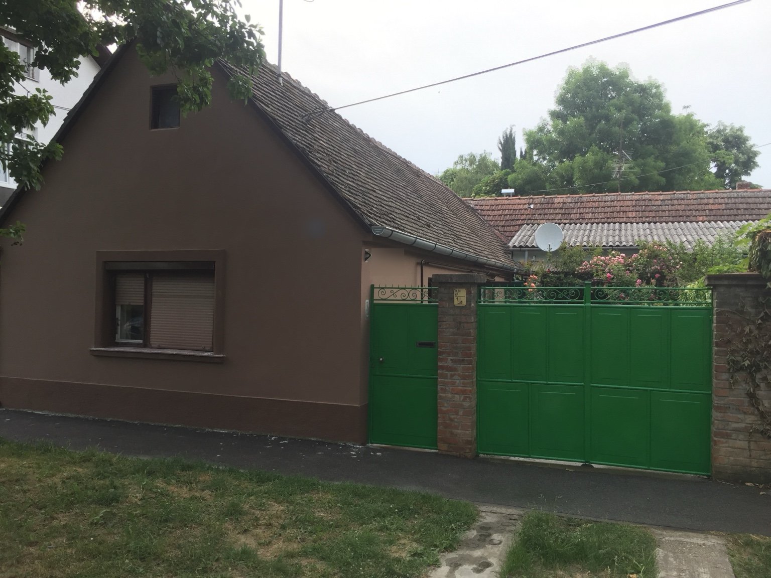 Ulična strana obiteljske kuće u Osijeku nakon obnove i bojanja fasade, cokla, stolarije i kapije.