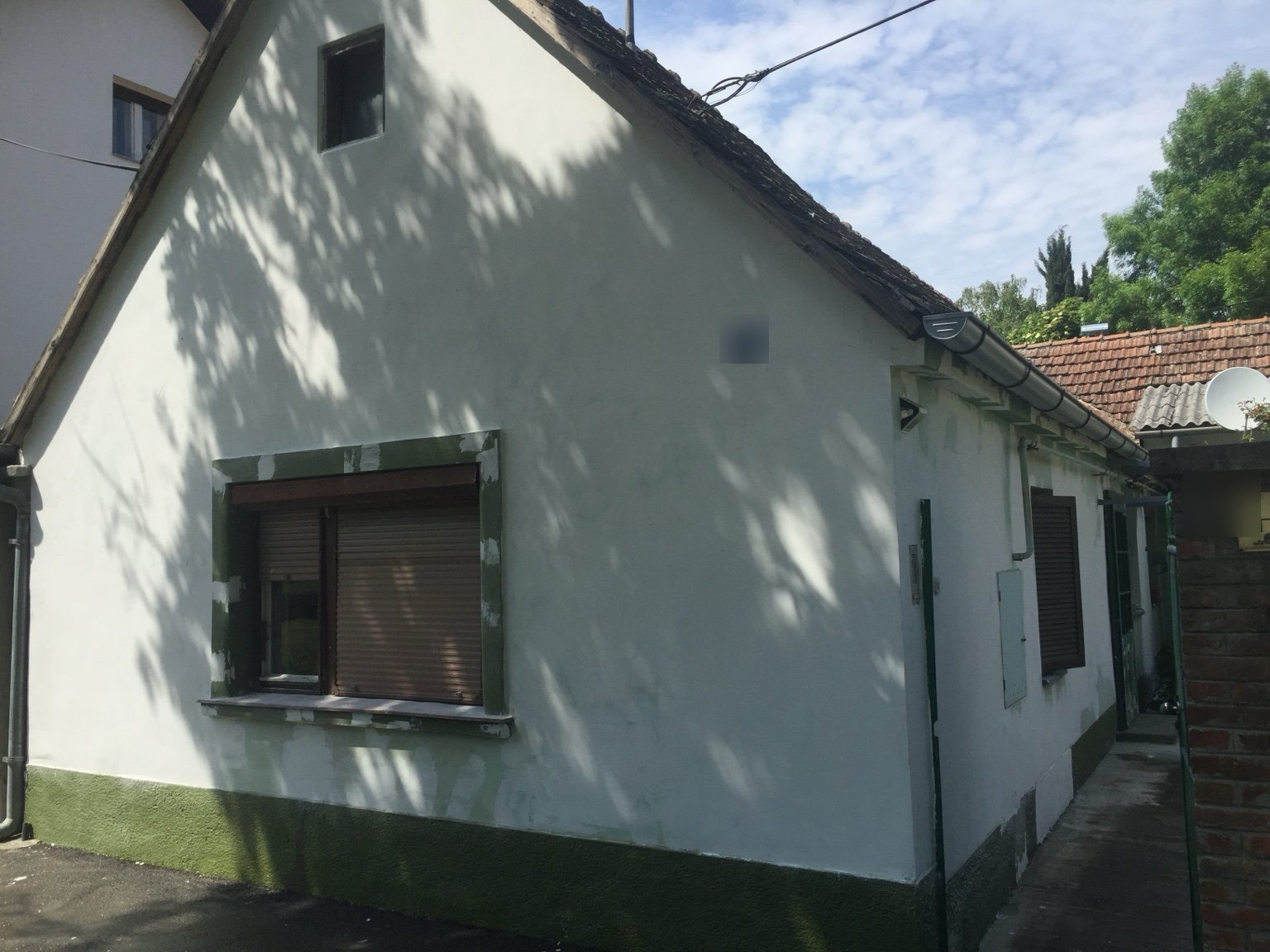 Ulična strana stare kuće u Osijeku prije bojanja fasade, s vidljivim starim coklom i pripremom oko otvora.