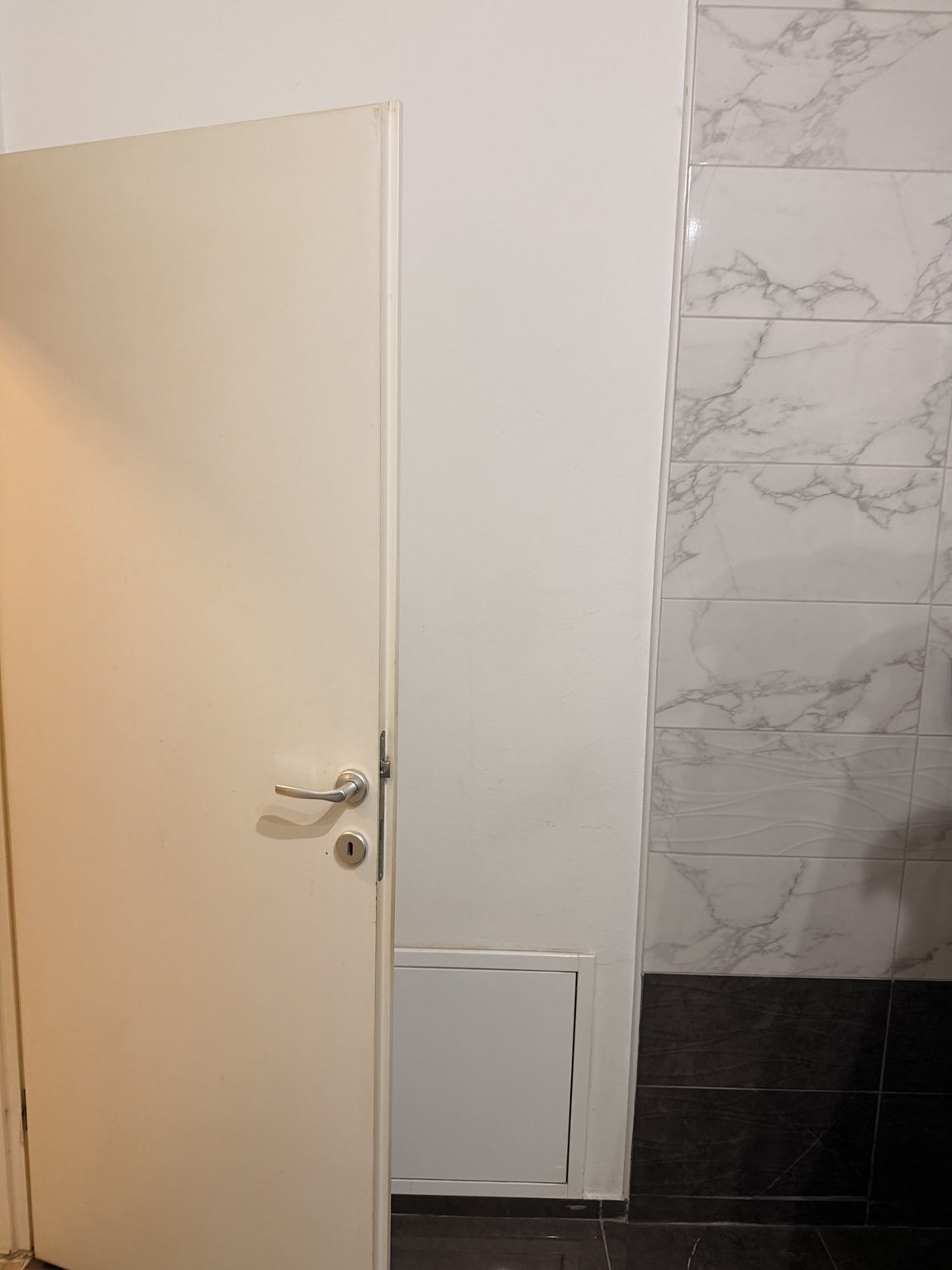 Detalj postojećih vrata i keramike prije završnog bojanja kupaonice u Osijeku.